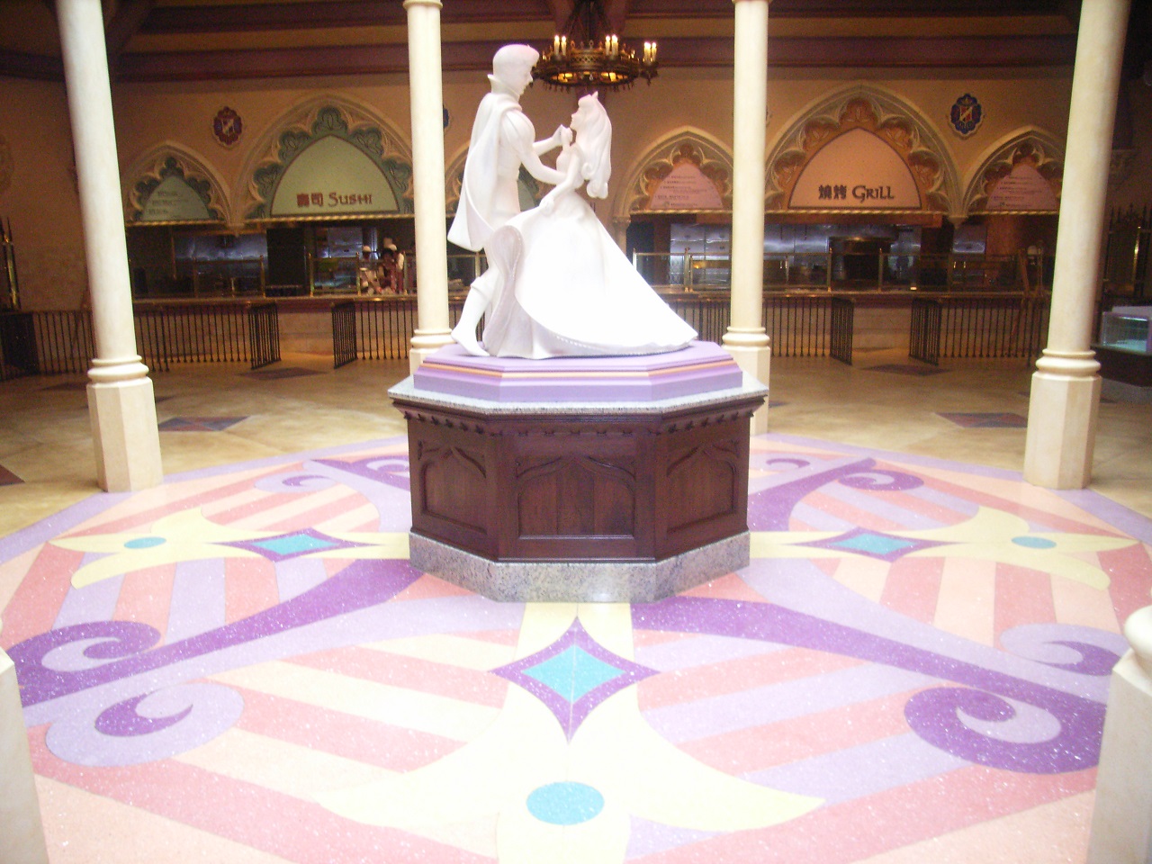 Wide shot of decorative flooring topped by a statue of a prince and princess