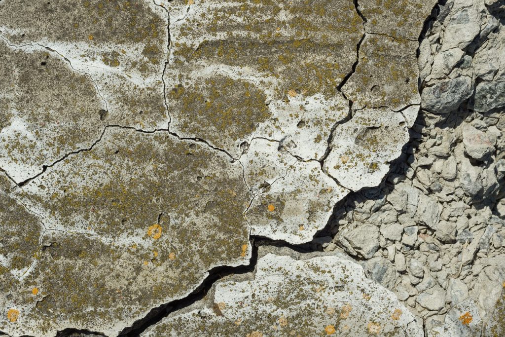 Close up of a dirty concrete floor full of cracks