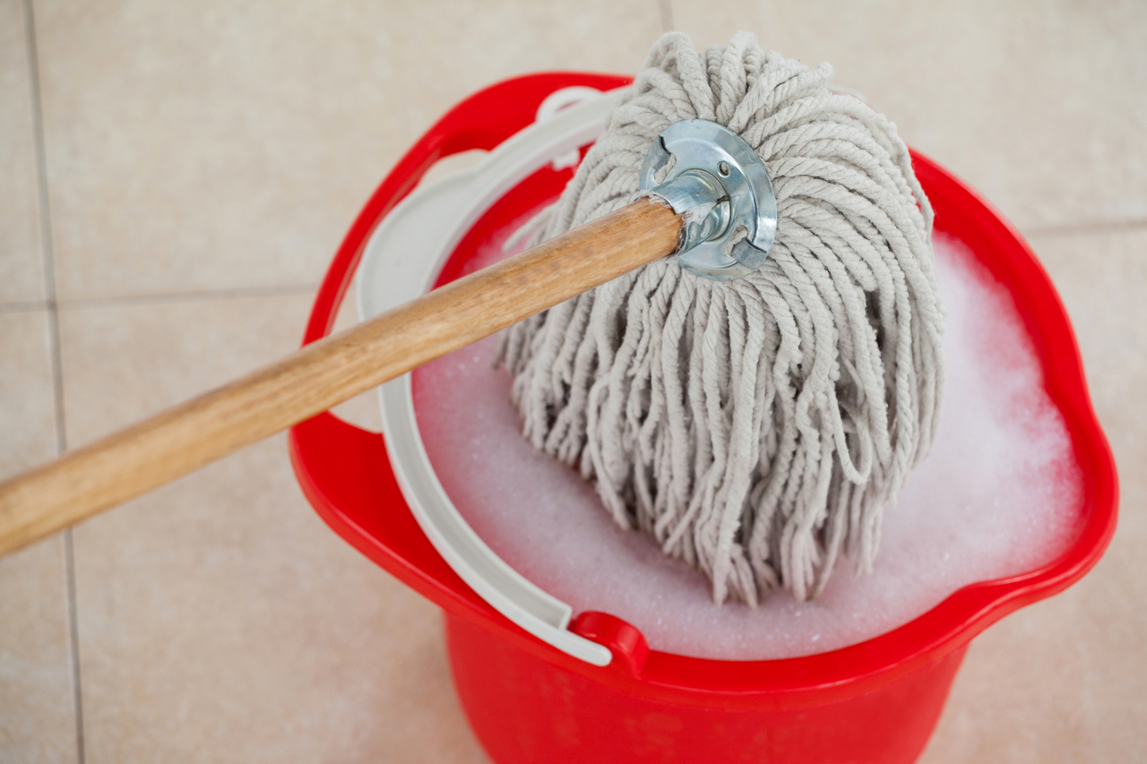 A bucket and mop to clean ceramic flooring