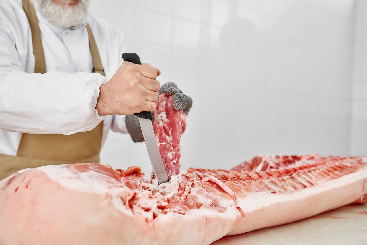 A butcher cutting up pork