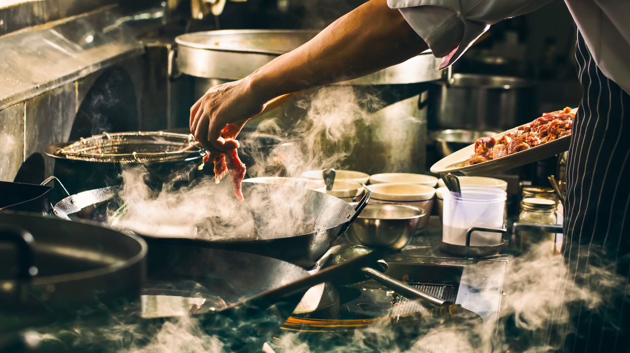 A cook in an industrial kitchen