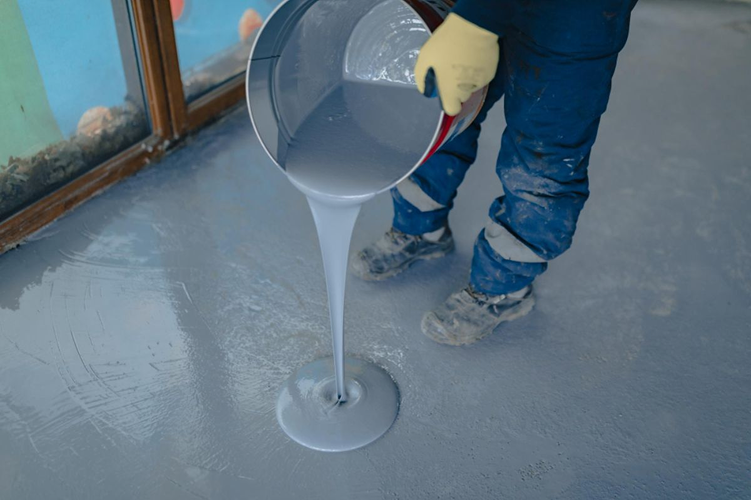 Waterproofing material being applied to a concrete floor