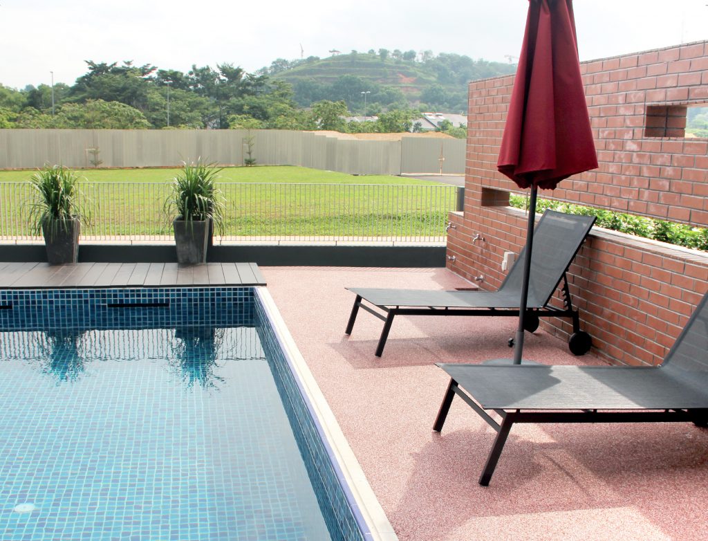 An outdoor pool with chairs and surrounding grass