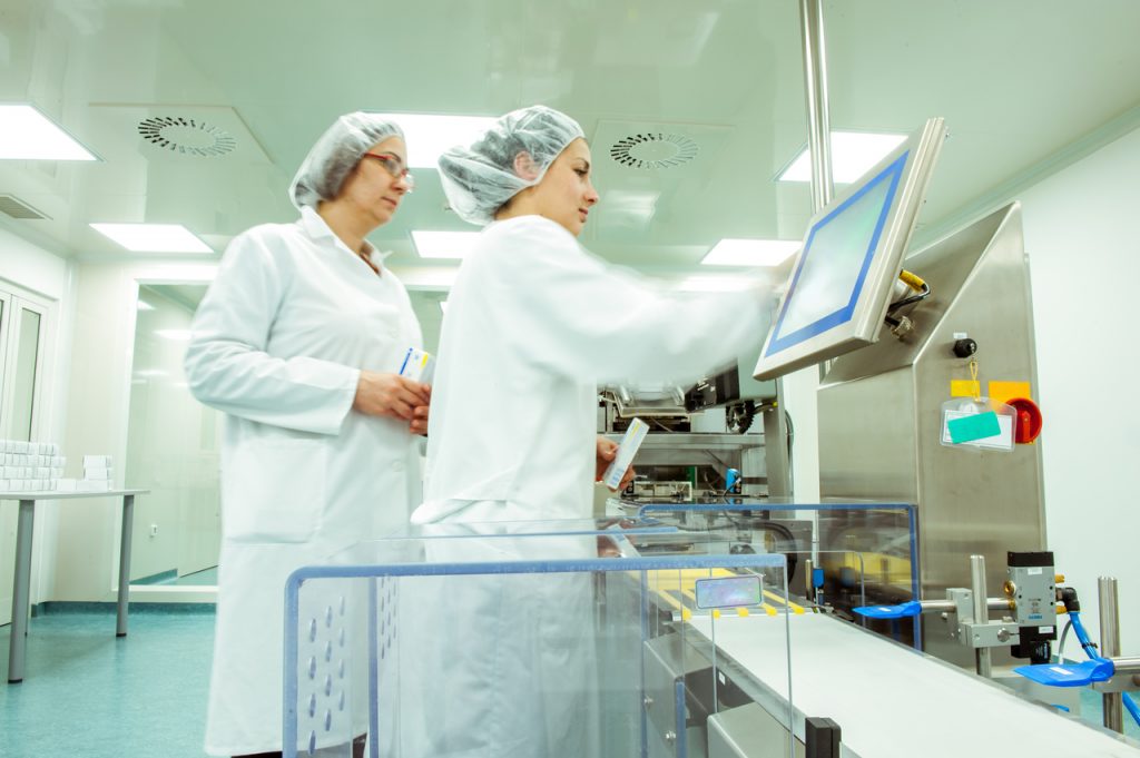 Two workers in a pharmaceutical facility