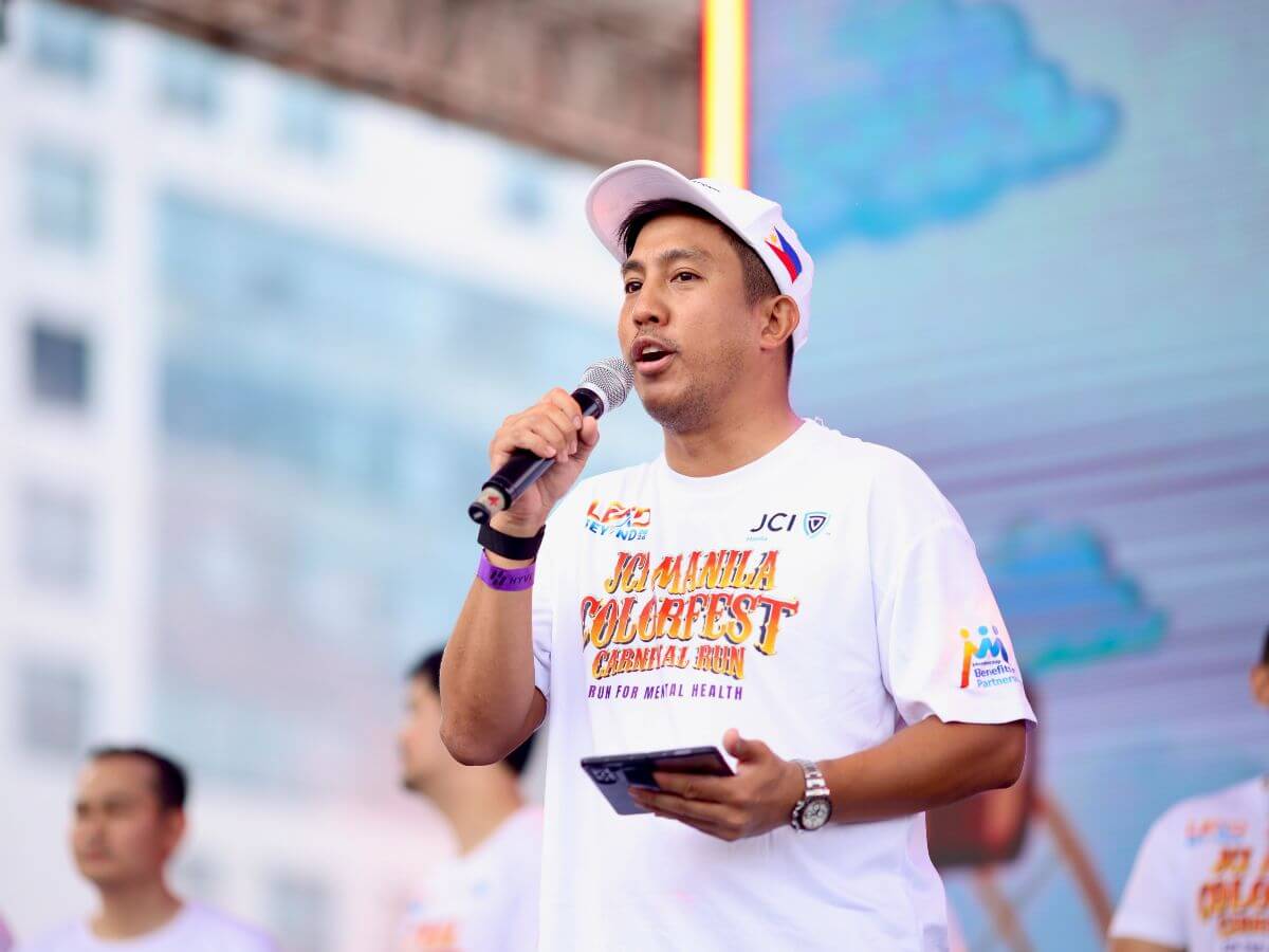 Anthony Laborte speaking onstage during the Colorfest Carnival Run for Mental Health
