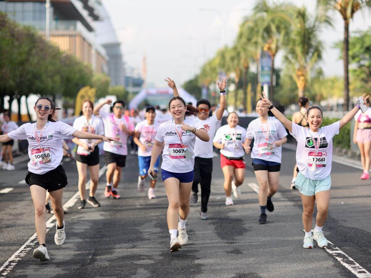 Smiling runners participating in the Colorfest Carnival Run at the SM Mall of Asia grounds.
Feature image: JCI Manila members and event partners posing beneath the Colorfest arch with a Run for Mental Health banner
