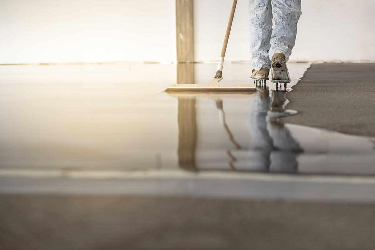 Worker installing epoxy flooring for a hard-wearing industrial surface