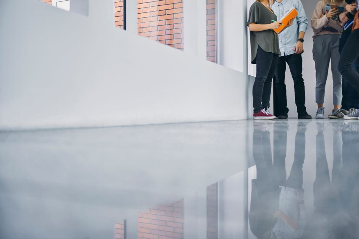 Glossy industrial flooring in a commercial facility with people standing in the background