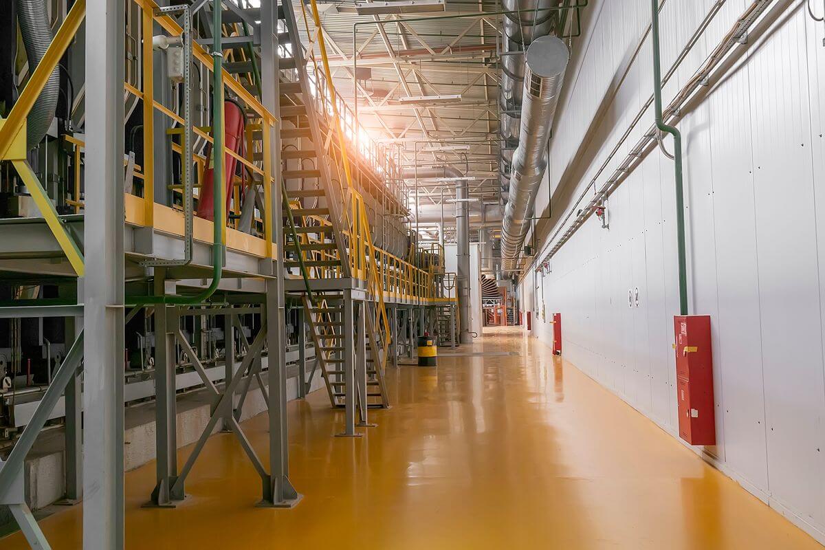 Industrial facility with durable yellow epoxy flooring, metal structures, and an organized production area