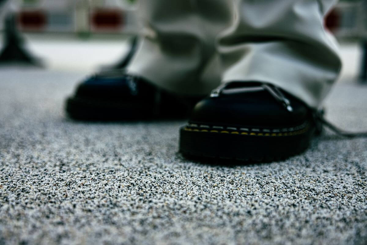 Close-up of safety shoes on a textured resin floor suitable for industrial and commercial facilities